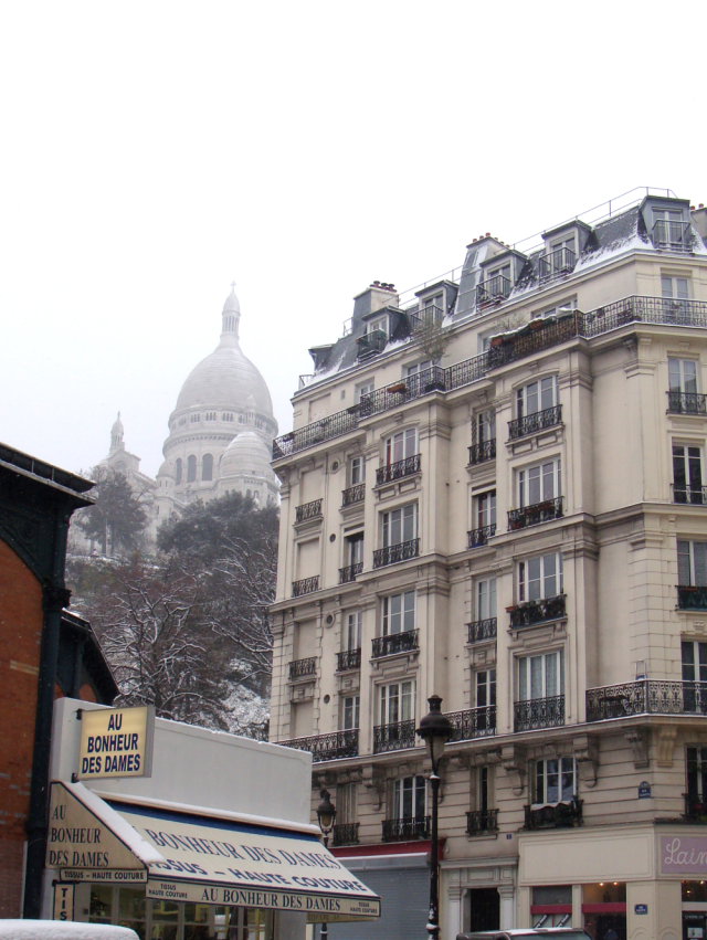 A view of the Sacre-Coeur with a fabric store to the left an a yarn shop on the right corner. Best view in Paris?